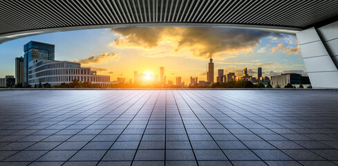 Empty square floor and city skyline with modern buildings at sunset in Ningbo, Zhejiang Province,...