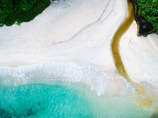 Drone bird eye of beautiful white sandy beach and turquoise water, and small river