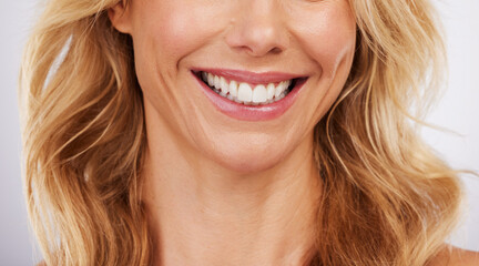 Closeup, smile and woman mouth in studio for dental, hygiene or teeth whitening on grey background....