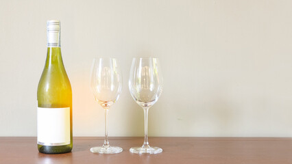 white wine bottle and glasses. Wine tasting experience on the wooden shelf with empty glass for lover couple in holiday. new year cheers romantic dinner celebration party table setting.