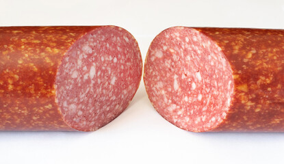 A sausage stick cut in half on a white isolated background