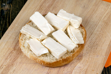 Wheat bun with large pieces of processed cheese inside