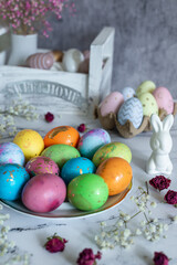 food composition. Beautiful multi -colored decorated Easter eggs and a cute white Easter rabbit on a white mromoic background