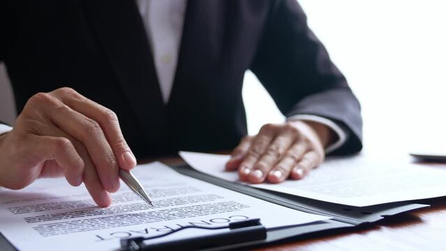 Attorneys or lawyers businessman signing or reading lawbook in office workplace for consultant lawyer concept.
