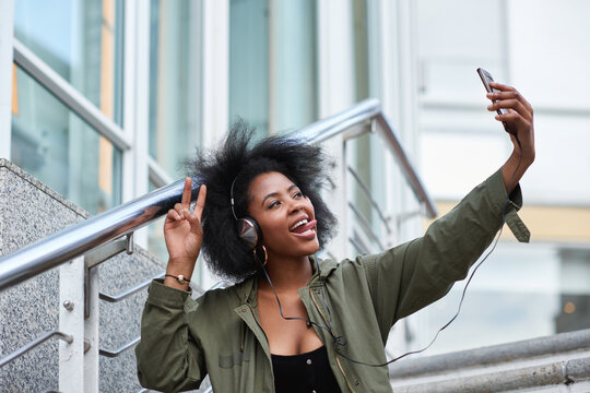 Selfie, campus and black woman student taking picture to update social media in a city with a peace sign or hand gesture. Photo, internet and young female making funny face with tongue online in town