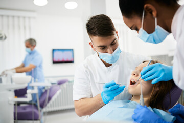 Teenage girl having teeth check-up during appointment with dentist.