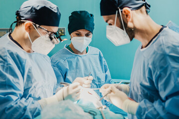Medical doctors team operating patient in surgical room at hospital - Focus on nurse woman face