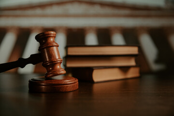 Wooden gavel close-up with law books on background. Law and Justice concept