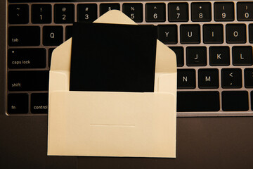 Paper envelope with card on a keyboard. Close-up