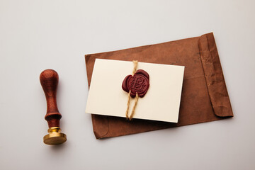 Paper envelope with red wax seal and stamp on a grey table, postal accessories