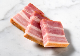 sliced smoked bacon on white marble surface