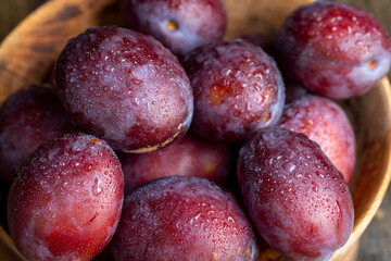 Ripe plums of dark color on the table
