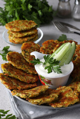 Baked zucchini pancakes with cheese and garlic, served for breakfast with sour cream, Close up