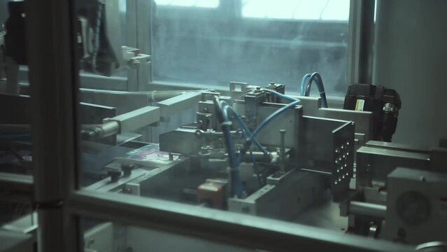 Mechanical high-tech automated metal machine packs products at the factory of products and sporting goods.