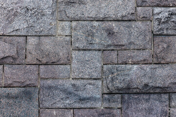 Old gray wall made of rough granite blocks. Close up background photo