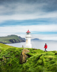 Fototapeta na wymiar Foggy view of old lighthouse on the Mykines island, Faroe islands, Denmark. Landscape photography