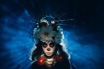 Woman with mexican skull halloween makeup on face. Day of the dead aka Dia de los Muertos and halloween party concept.