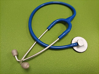 Blue stethoscope on green background
