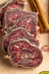 Unpeeled sliced pork salami with spices