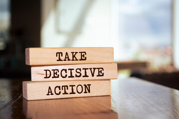 Wooden blocks with words 'TAKE DECISIVE ACTION'.