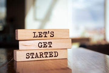 Wooden blocks with words 'Let's get started'. - obrazy, fototapety, plakaty