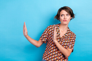 Photo of doubtful unsure lady dressed print shirt rising arms dislike empty space isolated blue color background