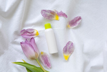 set of cosmetic products with flowers on white background