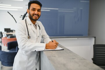 Portrait of confident Asian Indian medical doctor standing at hospital building