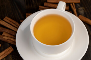 A white cup with green hot tea on a black board