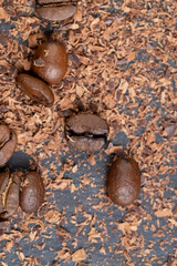 Roasted coffee beans lie together with chocolate crumbled into small pieces