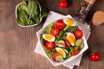 Appetizer healthy salad of fresh tomatoes, cucumber, spinach, lettuce and red onion. Vegan salad. Diet menu.