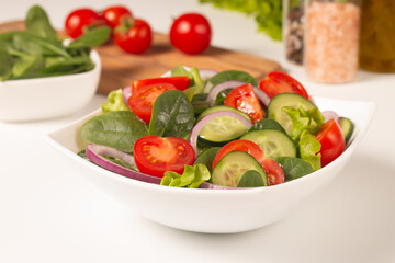 Appetizer healthy salad of fresh tomatoes, cucumber, spinach, lettuce and red onion. Vegan salad. Diet menu.