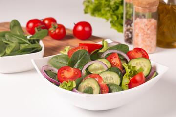Appetizer healthy salad of fresh tomatoes, cucumber, spinach, lettuce and red onion. Vegan salad. Diet menu.