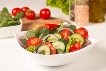 Appetizer healthy salad of fresh tomatoes, cucumber, spinach, lettuce and red onion. Vegan salad. Diet menu.