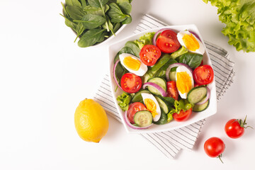 Appetizer healthy salad of fresh tomatoes, cucumber, spinach, lettuce and red onion. Vegan salad. Diet menu.