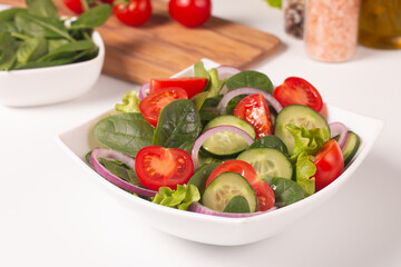 Appetizer healthy salad of fresh tomatoes, cucumber, spinach, lettuce and red onion. Vegan salad. Diet menu.