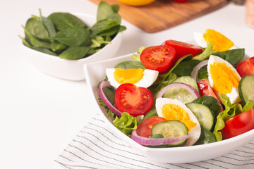 Appetizer healthy salad of fresh tomatoes, cucumber, spinach, lettuce and red onion. Vegan salad. Diet menu.