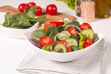 Appetizer healthy salad of fresh tomatoes, cucumber, spinach, lettuce and red onion. Vegan salad. Diet menu.