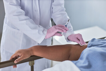 Minimal close up of nurse giving injection to senior patient in hospital, copy space