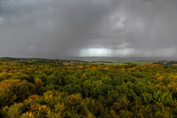 Rain clouds and rain over autumn landscape - 574297761