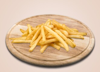 Freshly cooked tasty French fries on wooden board