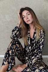a woman in colored clothes sits on the floor of a room