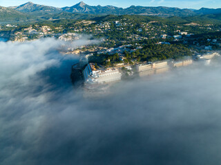 Aerial view, flight above the clouds, the coast of Mallorca in the fog with the town of Santa Ponca, Mallorca, Spain