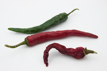 Close-up of some green and red Bell Peppers (capsicum) on a White Background at different times of...