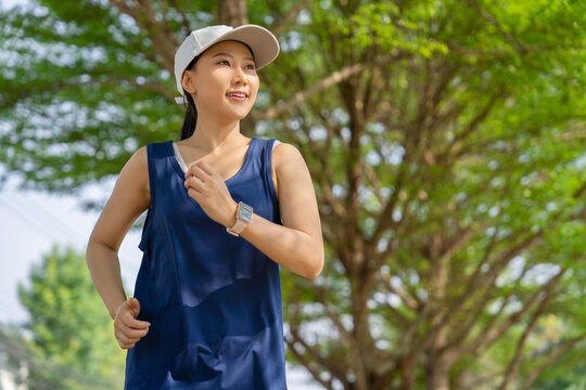 Female runner jogging at tropical garden - Powered by Adobe