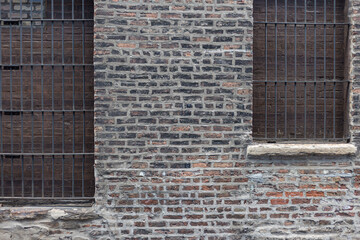 Vintage brick wall with iron bars covering the windows in alley in downtown Chicago - 574302718