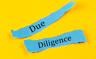 DUE DILIGENCE text on a blue pieces of paper on yellow background, business concept