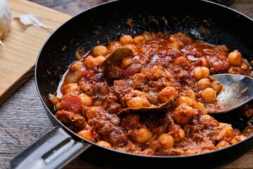 Camping meal chili con carne on wooden table.