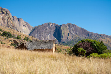 View of the Andringitra Massif with stone hut in the foreground and blue sky in the background. Andringitra National Park. 