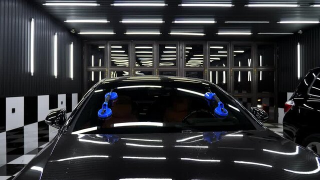 Close-up of the windshield that was removed with the help of suction cups in the car dealership. Repair of windows in a car service.